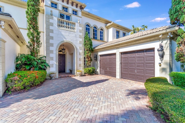 6404 Dorsay Ct, Delray Beach, FL 33484 - mediterranean / spanish-style home with an attached garage, decorative driveway, stucco siding, and stone siding