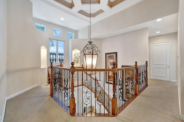 6404 Dorsay Ct, Delray Beach, FL 33484 - hall featuring an upstairs landing, carpet flooring, coffered ceiling, a high ceiling, and a chandelier