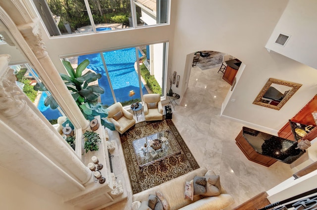 6404 Dorsay Ct, Delray Beach, FL 33484 - living area with a high ceiling, arched walkways, and healthy amount of natural light