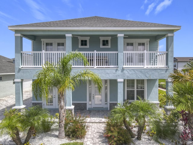 3121 Portofino Blvd, New Smyrna Beach, FL 32168 - coastal home featuring french doors, a balcony, a porch, and roof with shingles
