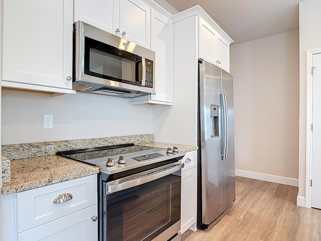 3121 Portofino Blvd, New Smyrna Beach, FL 32168 - kitchen featuring appliances with stainless steel finishes, light wood-style floors, white cabinets, and light stone countertops
