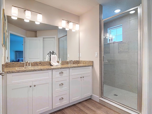 3121 Portofino Blvd, New Smyrna Beach, FL 32168 - bathroom featuring wood finished floors, double vanity, and a stall shower