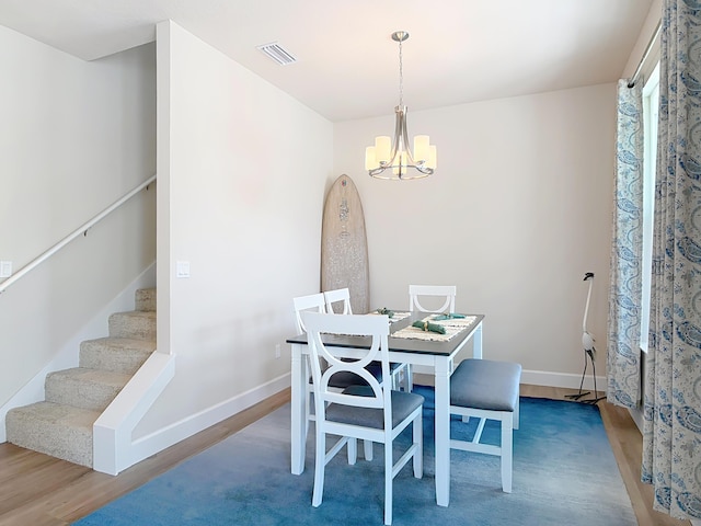 3121 Portofino Blvd, New Smyrna Beach, FL 32168 - dining area featuring a chandelier, wood finished floors, and stairway