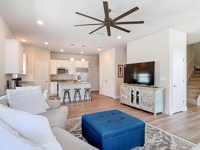 3121 Portofino Blvd, New Smyrna Beach, FL 32168 - living room with ceiling fan, light wood-type flooring, stairway, and recessed lighting