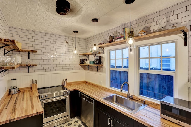 312 Central Dr, West Palm Beach, FL 33405 - kitchen featuring butcher block counters, appliances with stainless steel finishes, open shelves, dark cabinetry, and an ornate ceiling