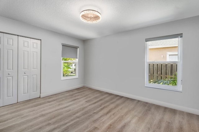 2051 SW Pruitt St, Port Saint Lucie, FL 34953 - unfurnished bedroom with wood finished floors, a closet, and a textured ceiling