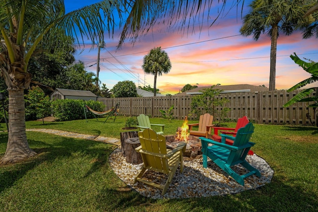 2051 SW Pruitt St, Port Saint Lucie, FL 34953 - yard at dusk featuring a fire pit and a storage unit