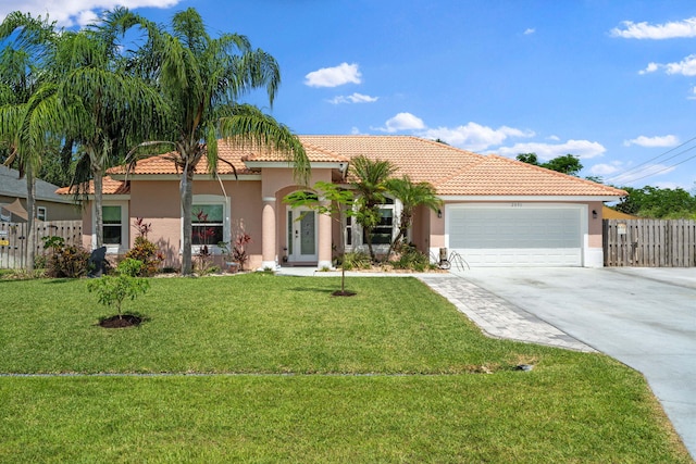 2051 SW Pruitt St, Port Saint Lucie, FL 34953 - mediterranean / spanish-style home with stucco siding, concrete driveway, an attached garage, and a tile roof