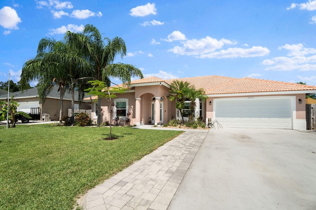 2051 SW Pruitt St, Port Saint Lucie, FL 34953 - mediterranean / spanish home with stucco siding, concrete driveway, a garage, a tile roof, and a front yard