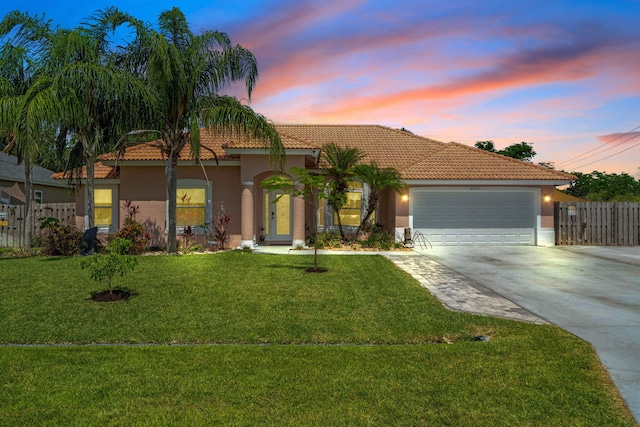 2051 SW Pruitt St, Port Saint Lucie, FL 34953 - view of front of home featuring stucco siding, concrete driveway, a tiled roof, and an attached garage