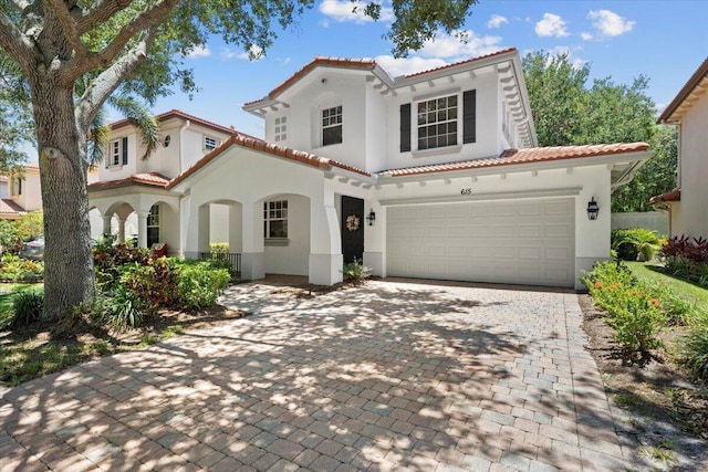 615 Castle Dr, Palm Beach Gardens, FL 33410 - mediterranean / spanish home featuring a tiled roof, stucco siding, and decorative driveway