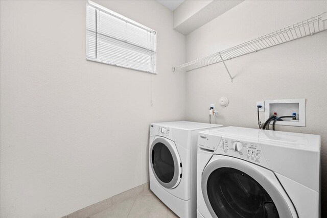 615 Castle Dr, Palm Beach Gardens, FL 33410 - laundry area with washer and clothes dryer and light tile patterned flooring