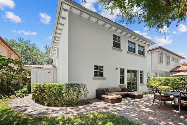 615 Castle Dr, Palm Beach Gardens, FL 33410 - back of property with stucco siding, a patio area, and an outdoor hangout area