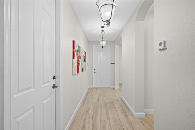 615 Castle Dr, Palm Beach Gardens, FL 33410 - hallway with arched walkways and light wood-style floors