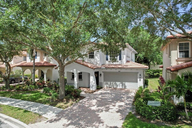 615 Castle Dr, Palm Beach Gardens, FL 33410 - mediterranean / spanish house with a garage, a tiled roof, driveway, and stucco siding