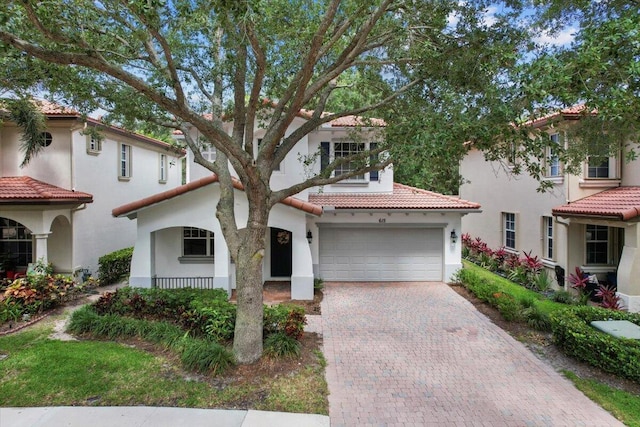 615 Castle Dr, Palm Beach Gardens, FL 33410 - mediterranean / spanish-style home with a tiled roof, stucco siding, decorative driveway, and a garage