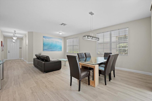 615 Castle Dr, Palm Beach Gardens, FL 33410 - dining room featuring light wood finished floors and a chandelier