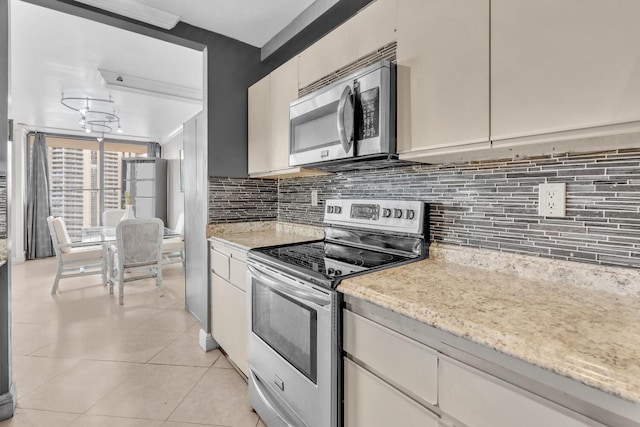 19667 Turnberry Way Unit 10C, Aventura, FL 33180 - kitchen with appliances with stainless steel finishes, light tile patterned flooring, decorative backsplash, and light stone countertops