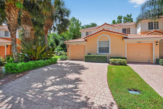 7271 Briella Dr, Boynton Beach, FL 33437 - mediterranean / spanish home with stucco siding, a garage, a tiled roof, and decorative driveway