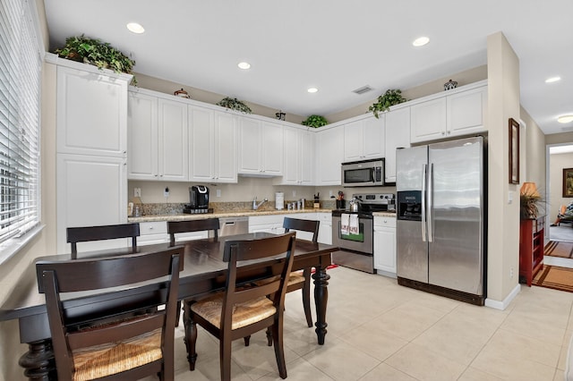 7271 Briella Dr, Boynton Beach, FL 33437 - kitchen featuring appliances with stainless steel finishes, recessed lighting, white cabinetry, light tile patterned flooring, and light stone countertops
