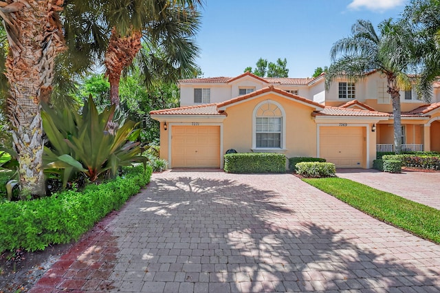 7271 Briella Dr, Boynton Beach, FL 33437 - mediterranean / spanish-style home featuring stucco siding, decorative driveway, a tile roof, and a garage