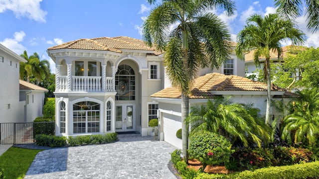 8168 Valhalla Dr, Delray Beach, FL 33446 - mediterranean / spanish-style home with french doors, a tiled roof, stucco siding, decorative driveway, and an attached garage