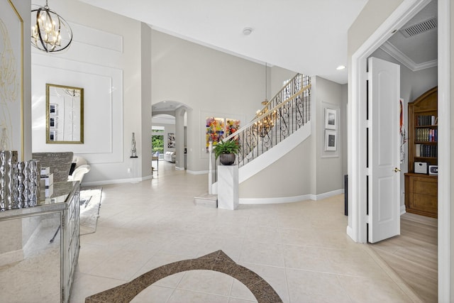 8168 Valhalla Dr, Delray Beach, FL 33446 - foyer with a chandelier, arched walkways, light tile patterned flooring, stairway, and ornamental molding