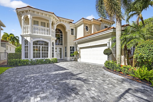8168 Valhalla Dr, Delray Beach, FL 33446 - mediterranean / spanish home with a balcony, french doors, stucco siding, decorative driveway, and a tile roof
