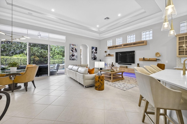 8168 Valhalla Dr, Delray Beach, FL 33446 - living area featuring arched walkways, healthy amount of natural light, crown molding, light tile patterned floors, and a raised ceiling