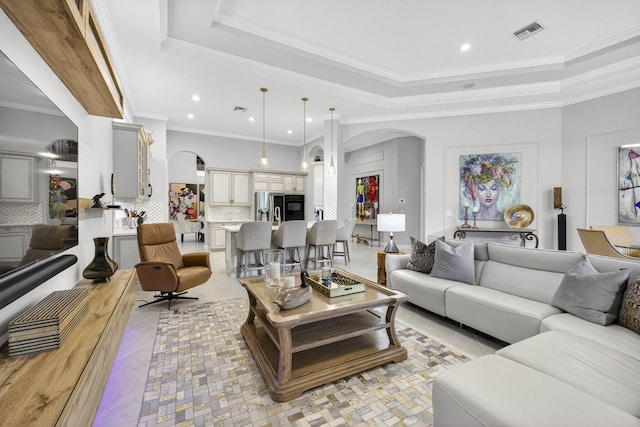 8168 Valhalla Dr, Delray Beach, FL 33446 - living room featuring arched walkways, a raised ceiling, ornamental molding, recessed lighting, and light tile patterned floors