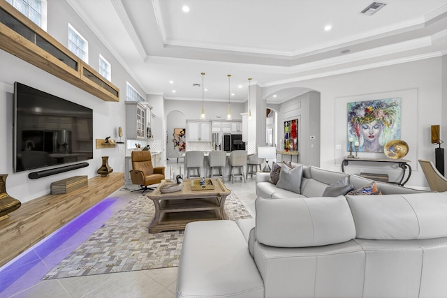8168 Valhalla Dr, Delray Beach, FL 33446 - tiled living room featuring arched walkways, a tray ceiling, recessed lighting, and ornamental molding