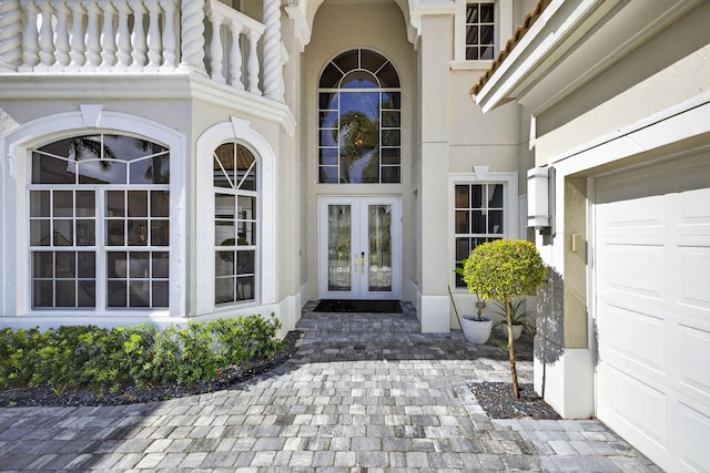 8168 Valhalla Dr, Delray Beach, FL 33446 - view of exterior entry featuring french doors, stucco siding, and a garage