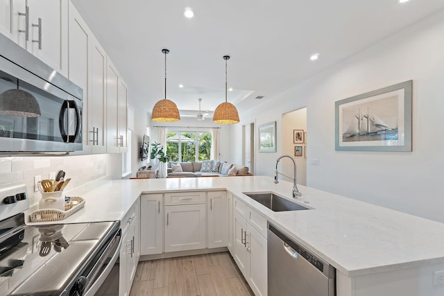17742 Evangeline Ave, Jupiter, FL 33458 - kitchen with stainless steel appliances, recessed lighting, tasteful backsplash, white cabinets, and decorative light fixtures