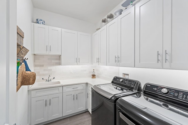 17742 Evangeline Ave, Jupiter, FL 33458 - laundry room featuring washing machine and clothes dryer, cabinet space, and light wood-type flooring