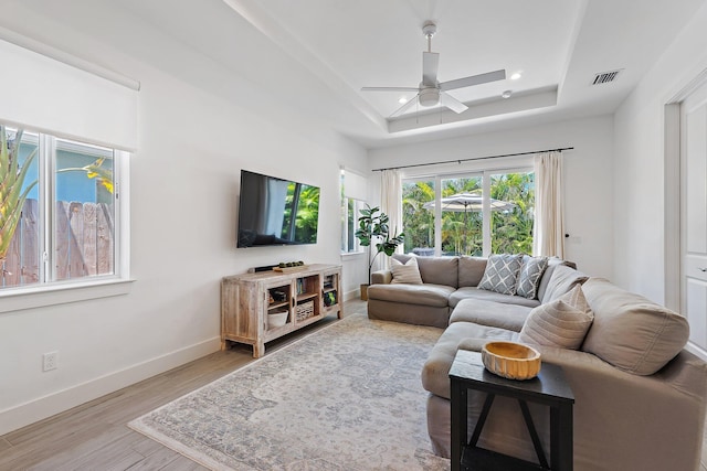 17742 Evangeline Ave, Jupiter, FL 33458 - living area with a tray ceiling, a ceiling fan, and wood finished floors