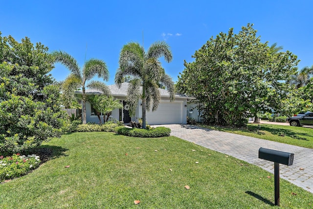 17742 Evangeline Ave, Jupiter, FL 33458 - view of front facade with an attached garage, a front lawn, and decorative driveway