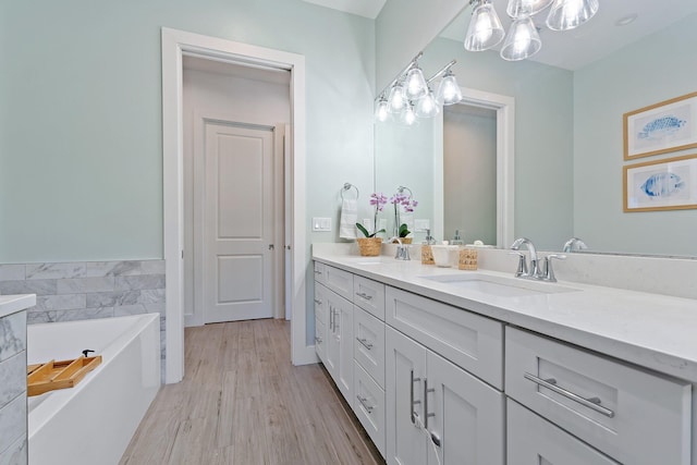 17742 Evangeline Ave, Jupiter, FL 33458 - bathroom with double vanity, a bath, a chandelier, wood finished floors, and tile walls