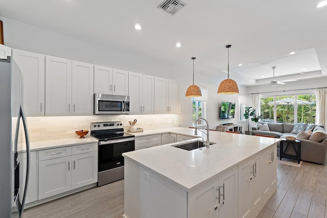 17742 Evangeline Ave, Jupiter, FL 33458 - kitchen featuring stainless steel appliances, decorative backsplash, light countertops, open floor plan, and recessed lighting