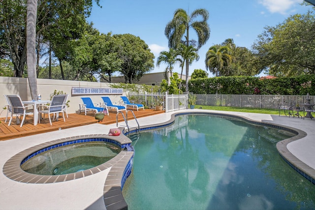 2002 Valencia Dr, Delray Beach, FL 33445 - view of swimming pool with a wooden deck, a fenced backyard, outdoor dining area, and a pool with connected hot tub