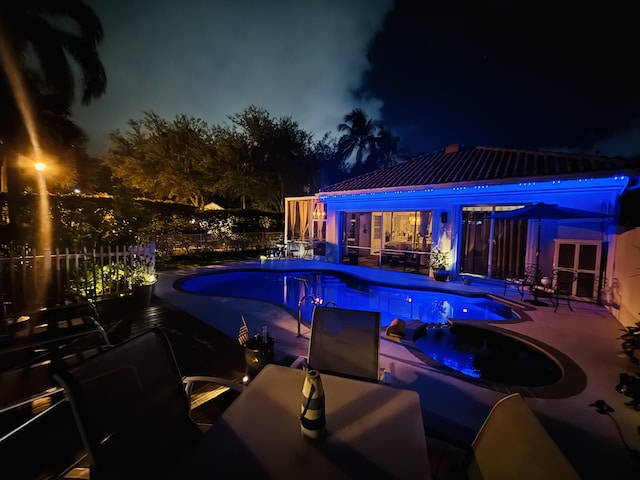 2002 Valencia Dr, Delray Beach, FL 33445 - pool at night with a patio and a jacuzzi