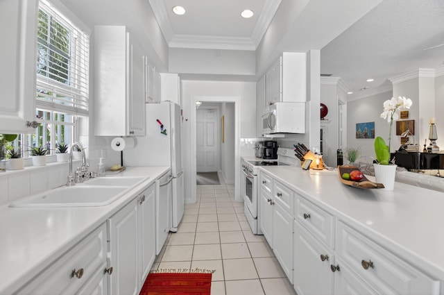 2002 Valencia Dr, Delray Beach, FL 33445 - kitchen with white appliances, healthy amount of natural light, white cabinetry, light tile patterned floors, and recessed lighting