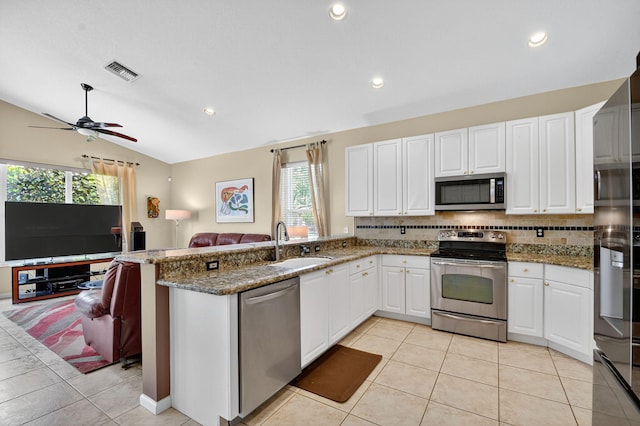 11291 Barca Blvd, Boynton Beach, FL 33437 - kitchen featuring appliances with stainless steel finishes, decorative backsplash, open floor plan, vaulted ceiling, and light tile patterned floors