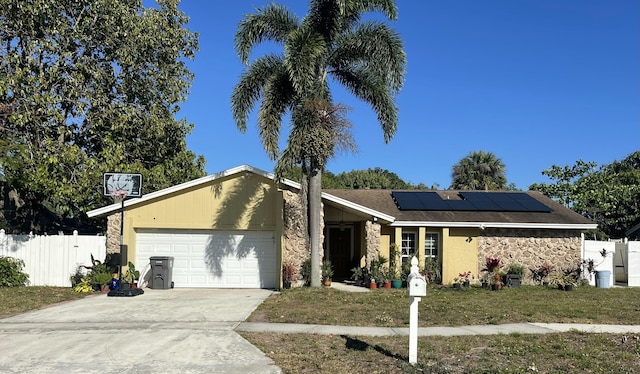 1186 Camprock Rd, West Palm Beach, FL 33417 - mid-century inspired home with an attached garage, roof mounted solar panels, driveway, and stone siding