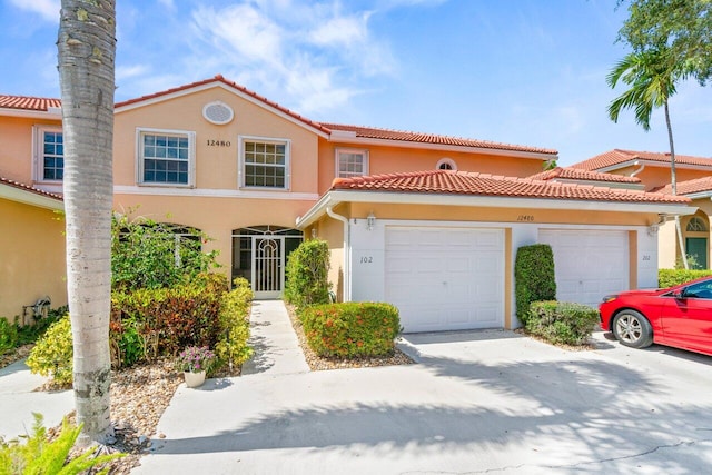 12480 Crystal Pointe Dr Unit 102, Boynton Beach, FL 33437 - view of property with an attached garage, stucco siding, and a tiled roof