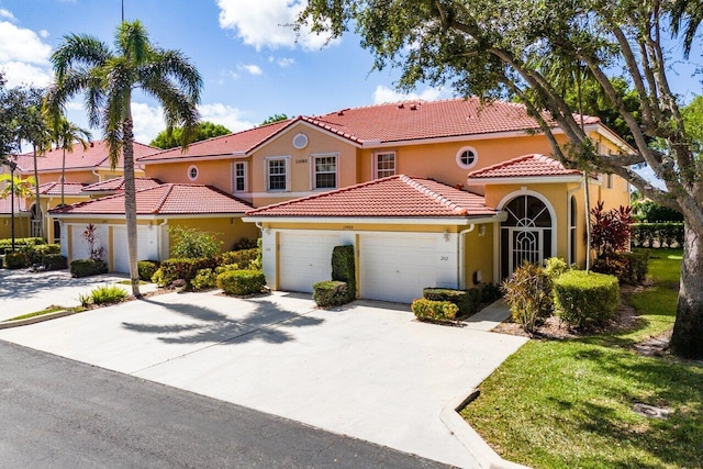 12480 Crystal Pointe Dr Unit 102, Boynton Beach, FL 33437 - mediterranean / spanish house featuring an attached garage, a tile roof, concrete driveway, and stucco siding
