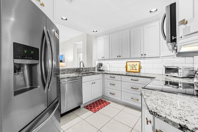 12480 Crystal Pointe Dr Unit 102, Boynton Beach, FL 33437 - kitchen featuring appliances with stainless steel finishes, light stone countertops, light tile patterned flooring, white cabinets, and backsplash