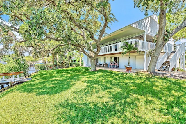 2438 Inland Cove Rd, Palm Beach Gardens, FL 33410 - view of grassy yard featuring a ceiling fan and stairway