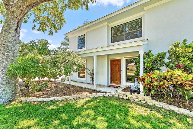 2438 Inland Cove Rd, Palm Beach Gardens, FL 33410 - view of front facade featuring stucco siding and a front yard