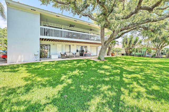 2438 Inland Cove Rd, Palm Beach Gardens, FL 33410 - rear view of property featuring a lawn, stucco siding, an outdoor living space, and a patio