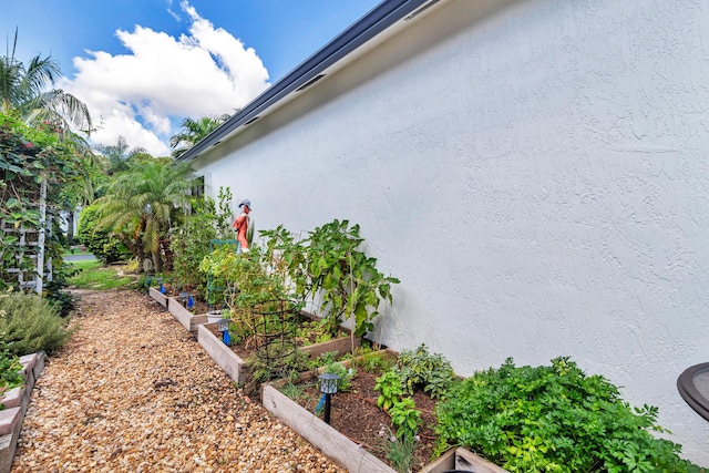 63 Lake Eden Dr, Boynton Beach, FL 33435 - view of home's exterior with stucco siding and a garden
